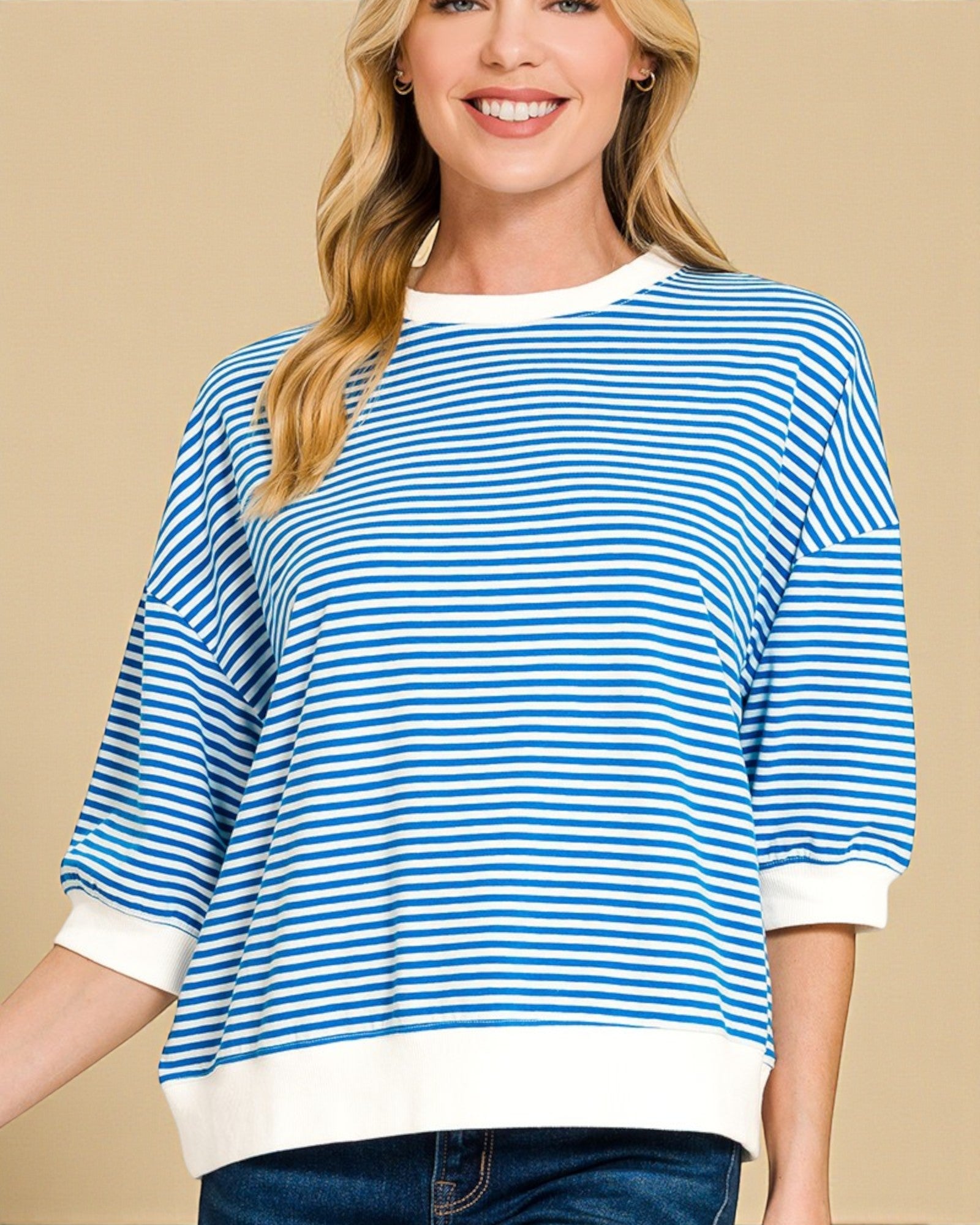 Woman wearing a blue and white striped shirt on a beige background