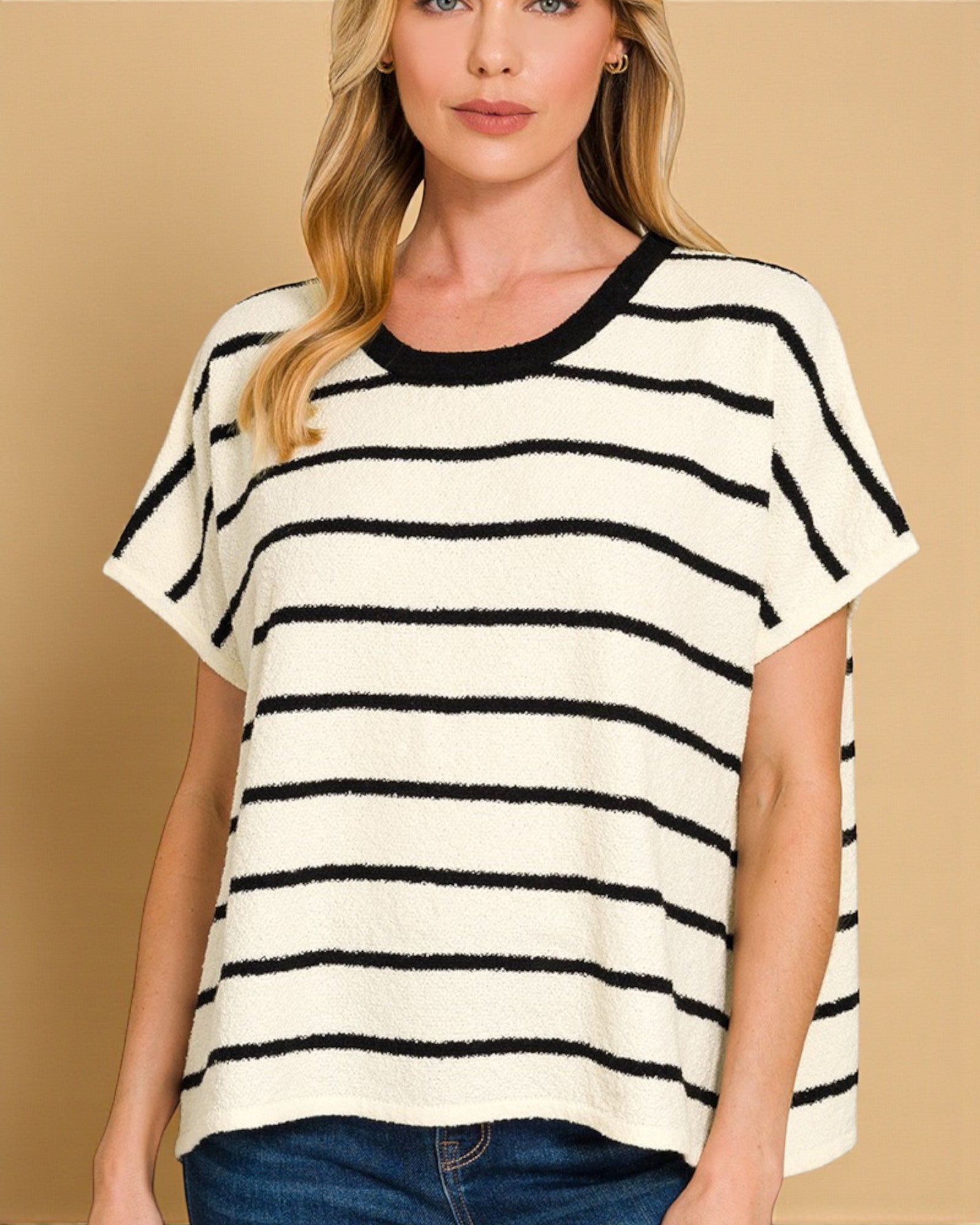 Woman wearing a black and white striped shirt against a beige background