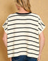 Person wearing a black and white striped sweater against a beige background