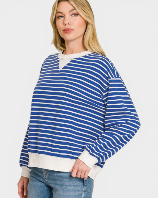 Woman wearing a blue and white striped sweater on a plain background