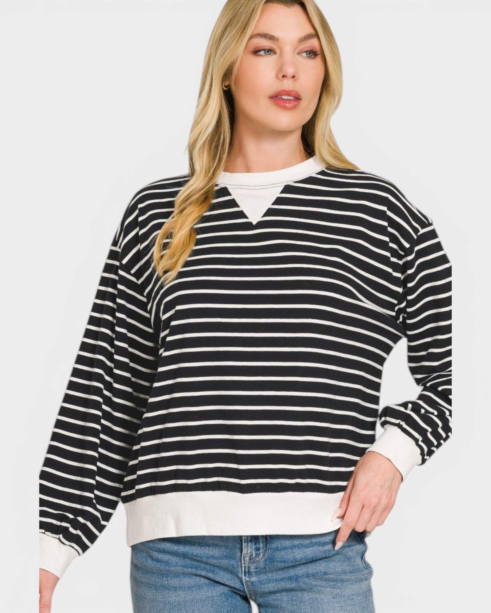 Woman wearing a black and white striped sweater with a plain background