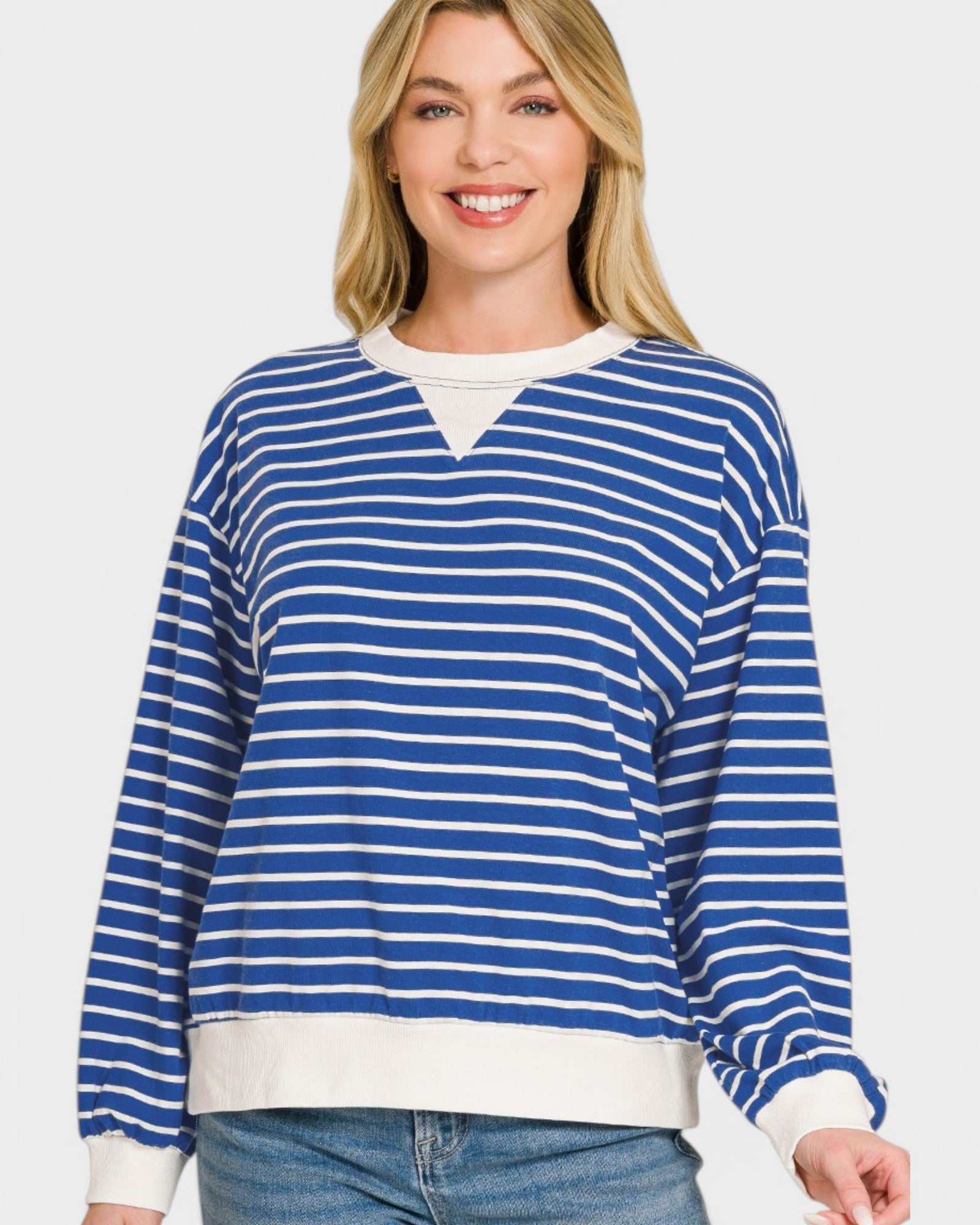 Woman wearing a blue and white striped sweater on a plain background