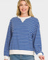 Woman wearing a blue and white striped sweater on a plain background