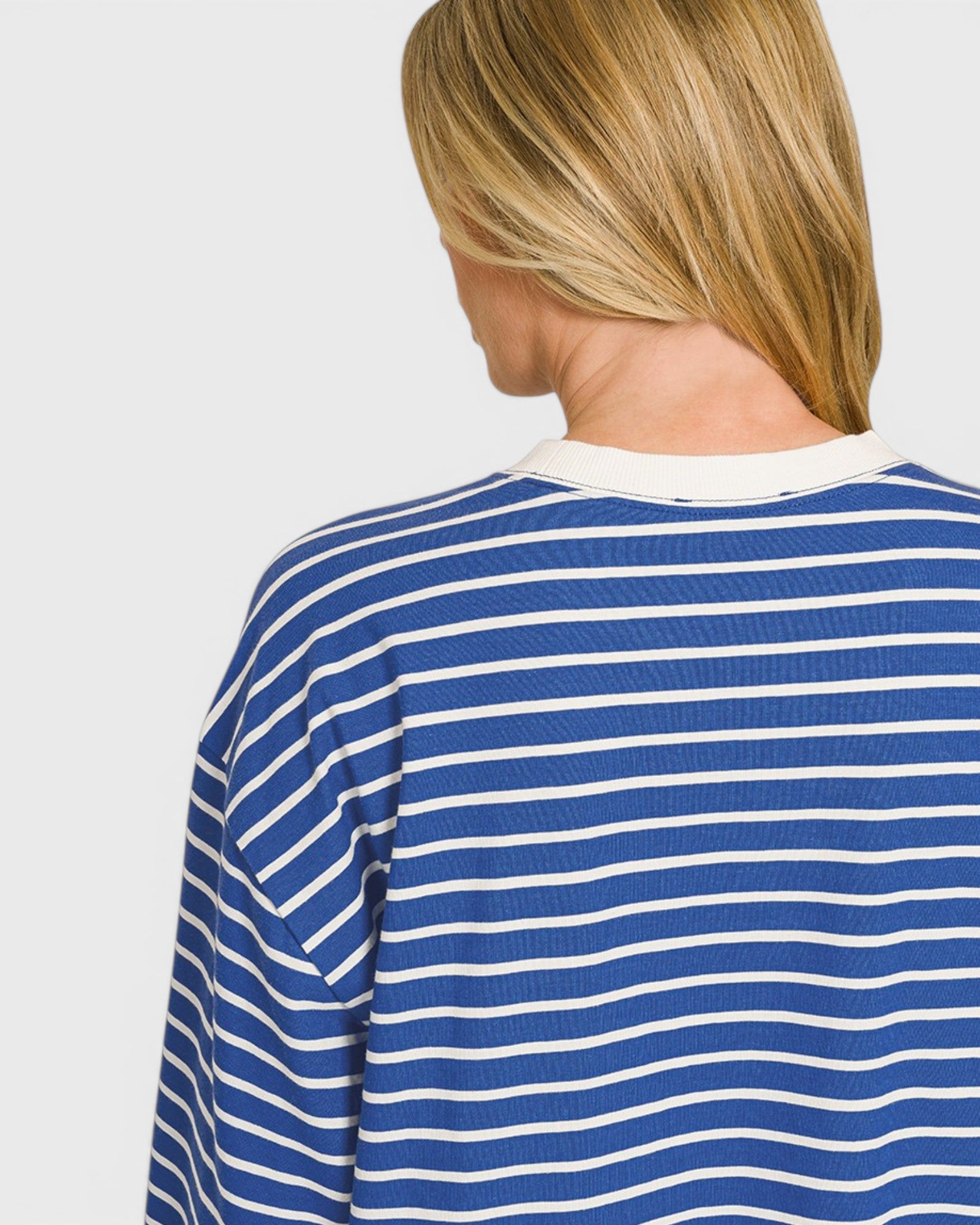 Person wearing a blue and white striped shirt on a plain background