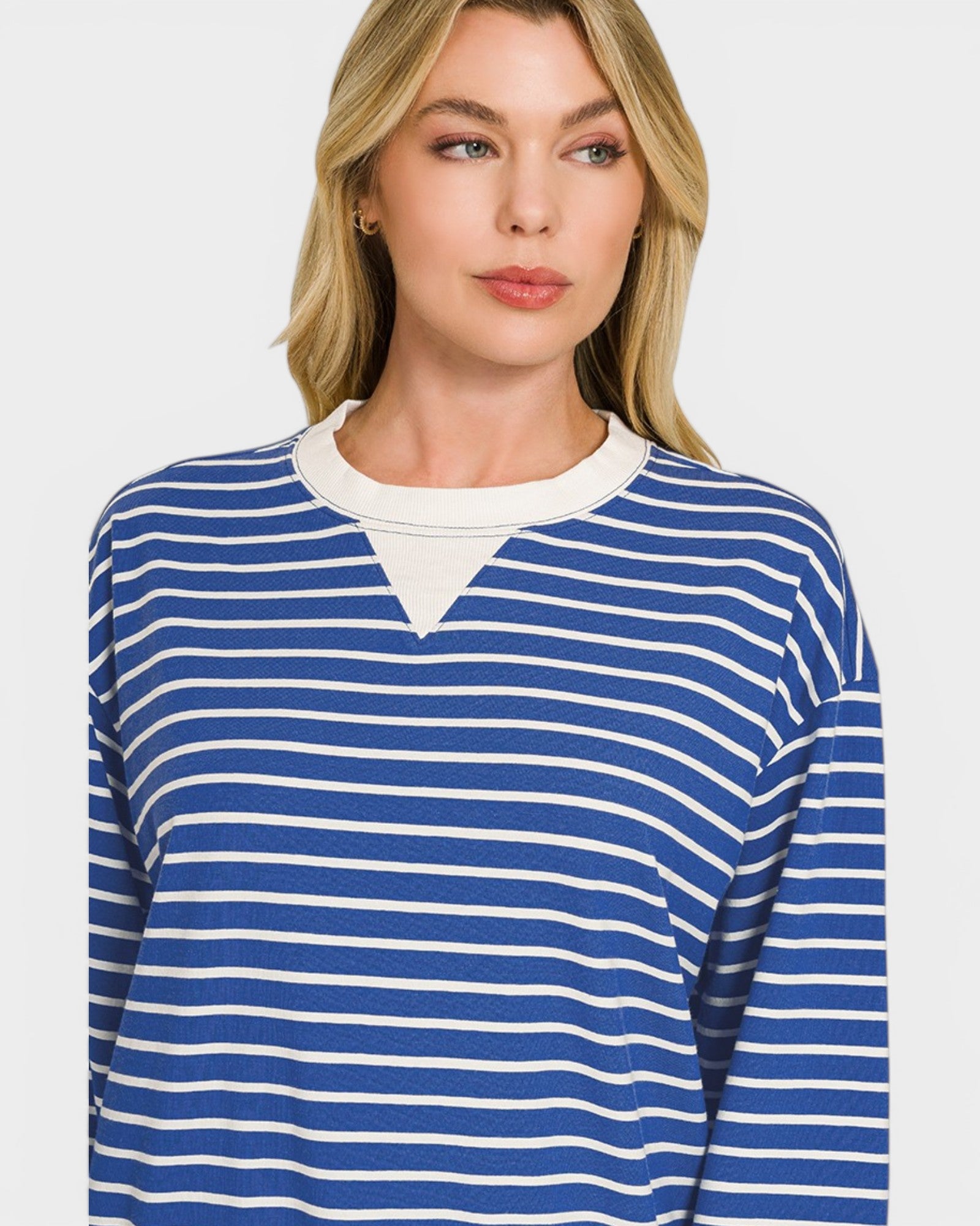Woman wearing a blue and white striped long-sleeve shirt on a plain background