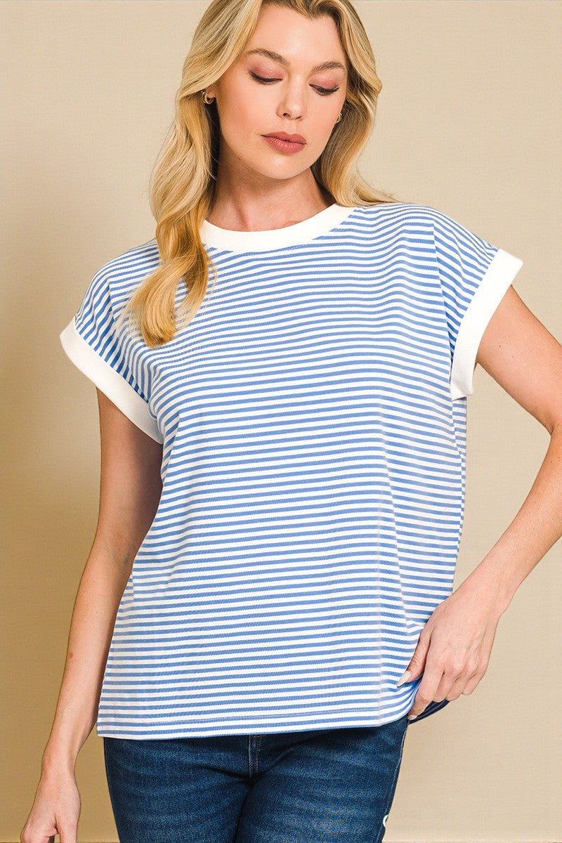 Woman wearing a blue and white striped shirt against a beige background