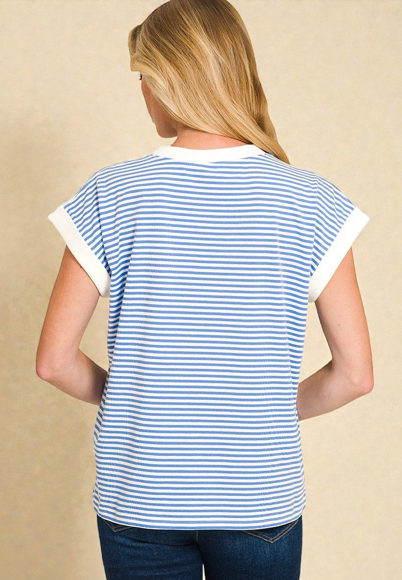 Person wearing a blue and white striped shirt with a beige background