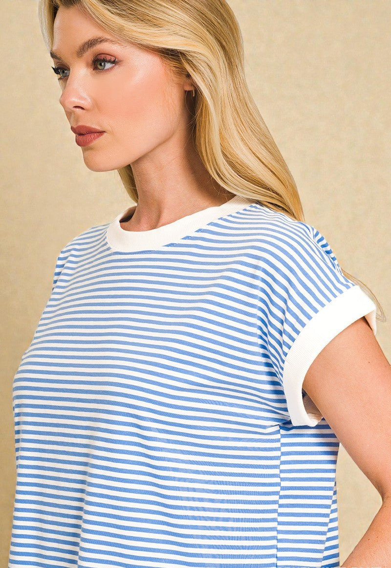 Woman wearing a blue and white striped shirt against a beige background