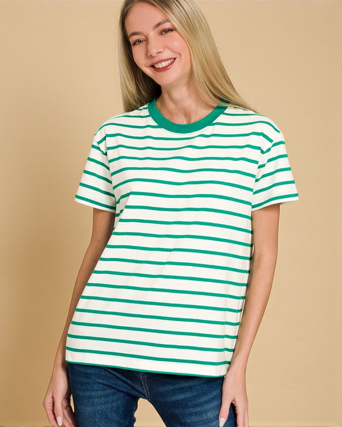 Woman wearing a green and white striped t-shirt against a beige background