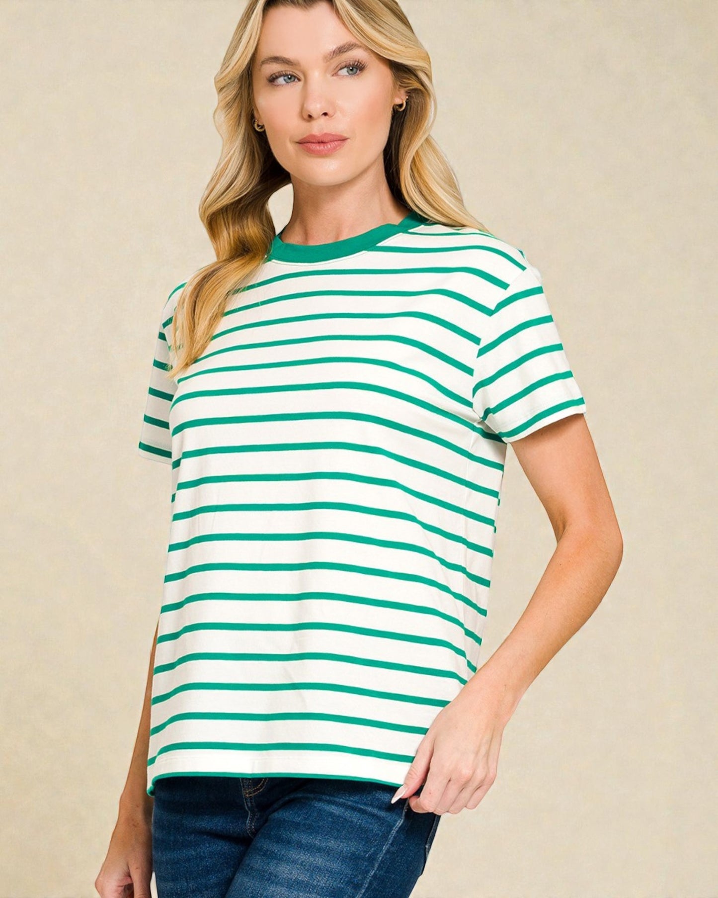 Woman wearing a green and white striped t-shirt against a beige background
