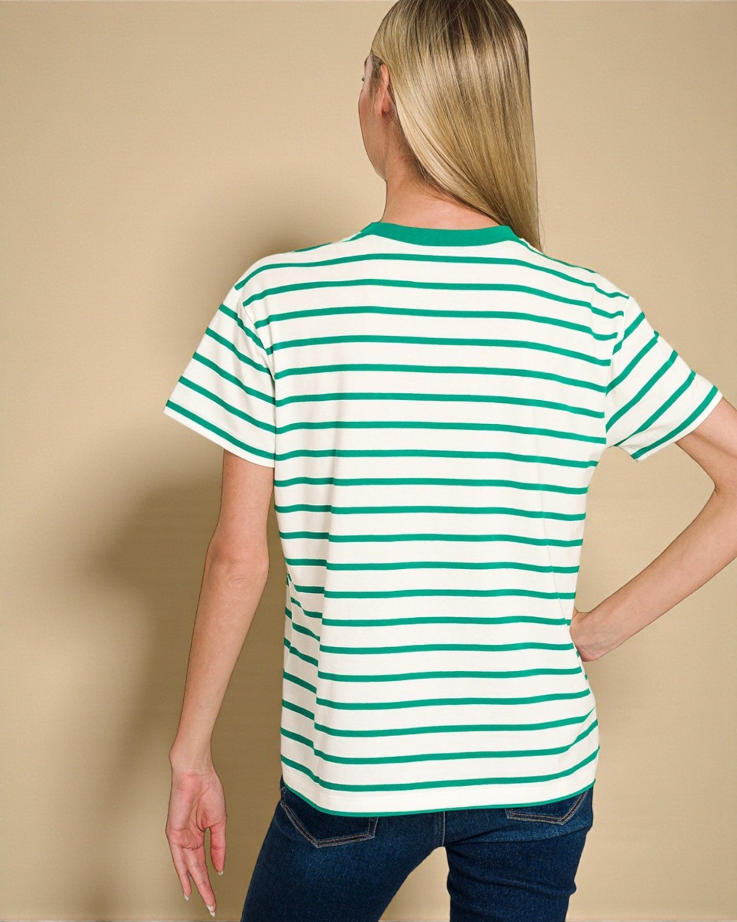 Person wearing a green and white striped shirt against a beige background