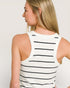 Woman wearing a white tank top with black stripes from the back