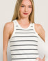 Woman wearing a white tank top with black stripes against a plain background