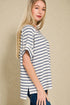 Woman wearing a blue and white striped shirt against a beige background