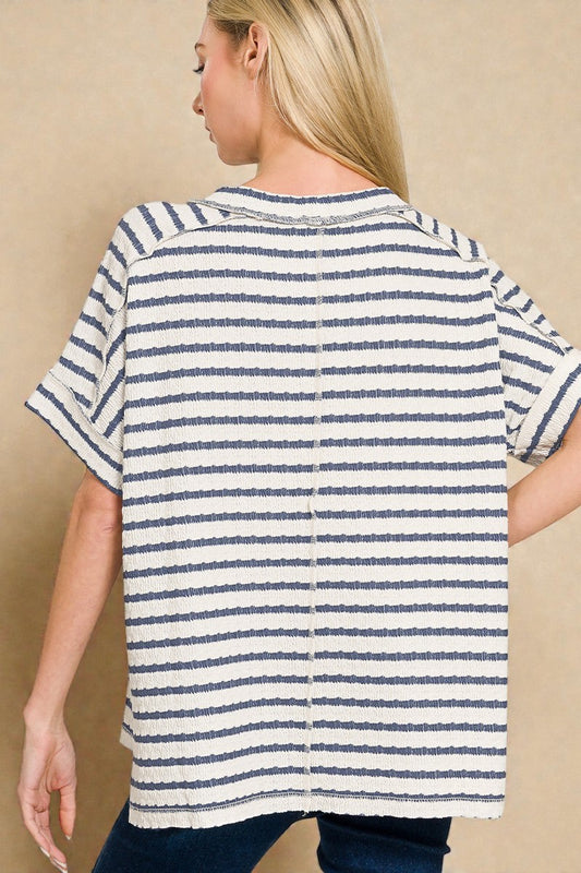 Woman wearing a blue and white striped shirt against a beige background