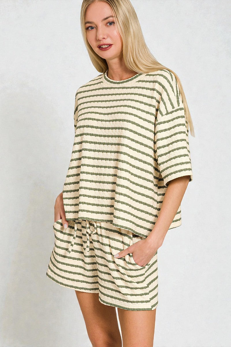 Woman wearing a striped outfit with a plain background