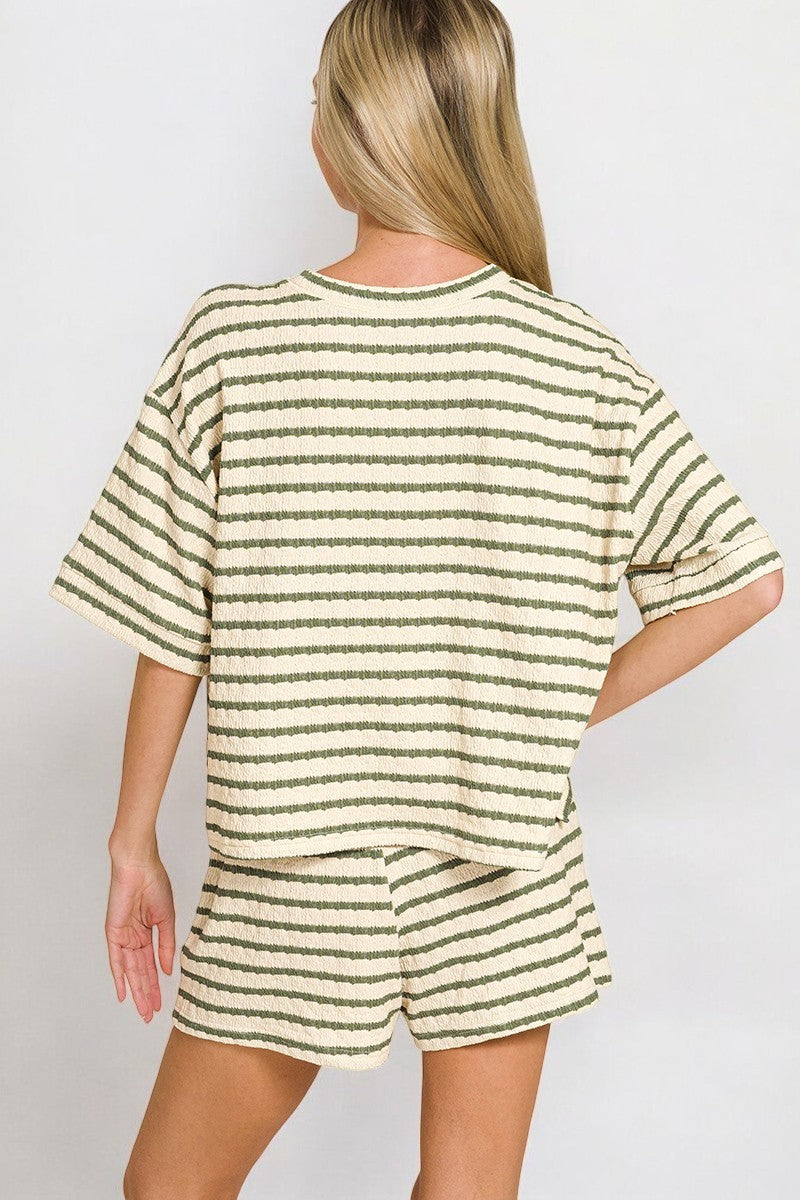 Person wearing a green and white striped outfit on a plain background