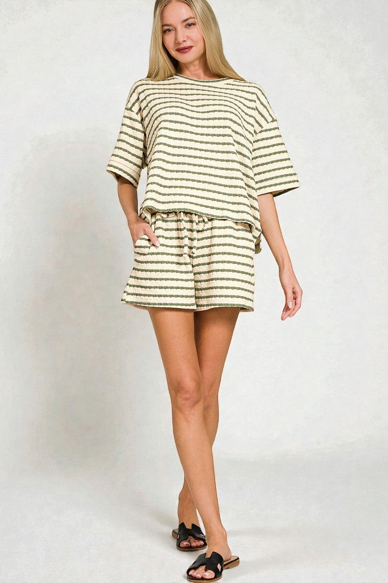 Woman wearing a striped outfit on a plain background