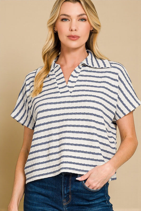 Woman wearing a striped short-sleeve shirt against a beige background