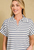Woman wearing a blue and white striped polo shirt against a beige background