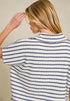 Person wearing a blue and white striped shirt against a beige background
