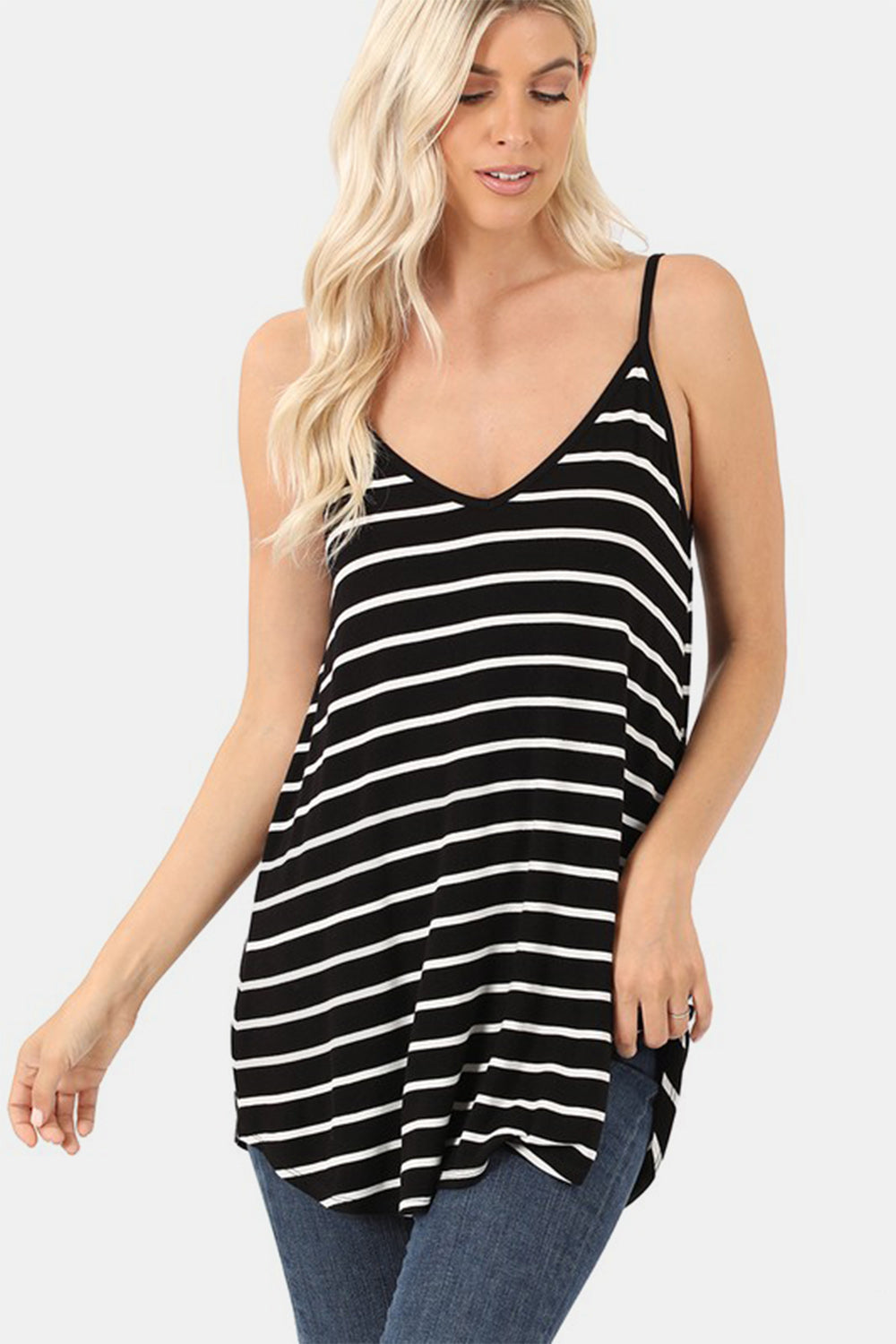 Woman wearing a black and white striped tank top against a plain background