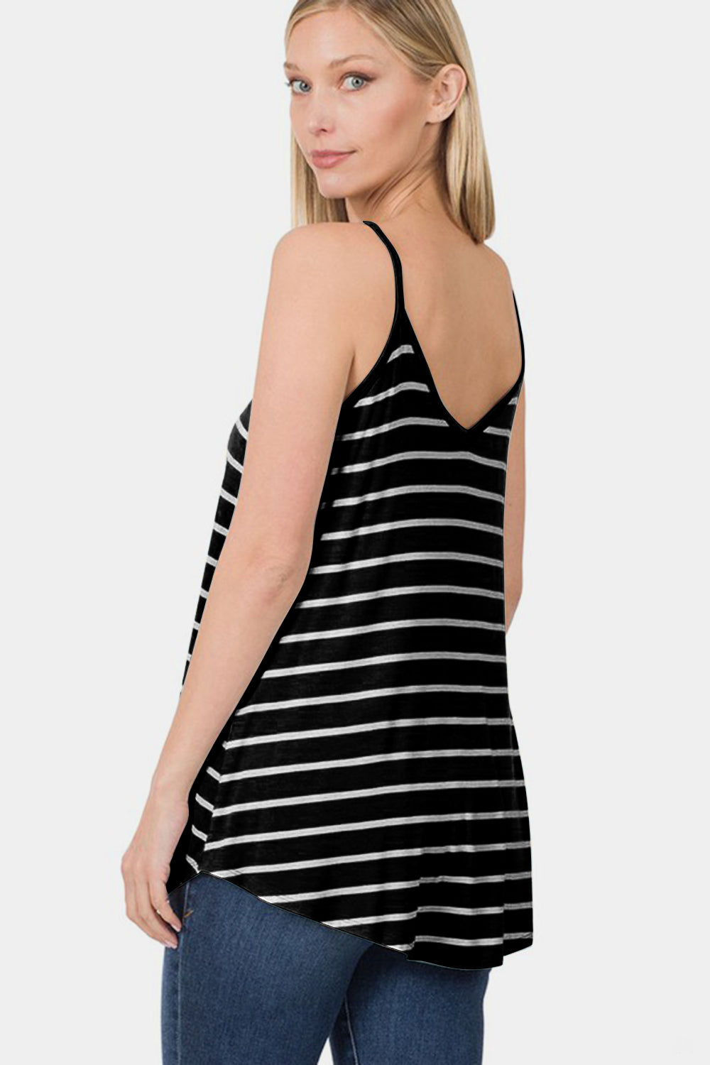 Woman wearing a black and white striped tank top against a plain background