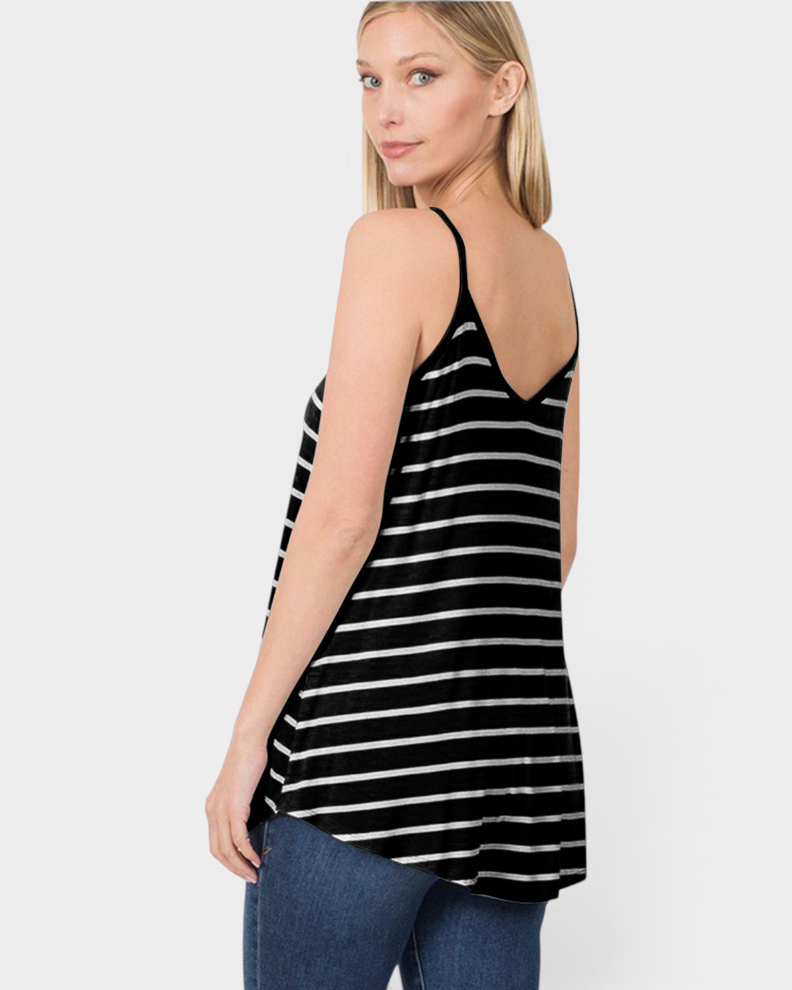 Woman wearing a black and white striped tank top on a plain background