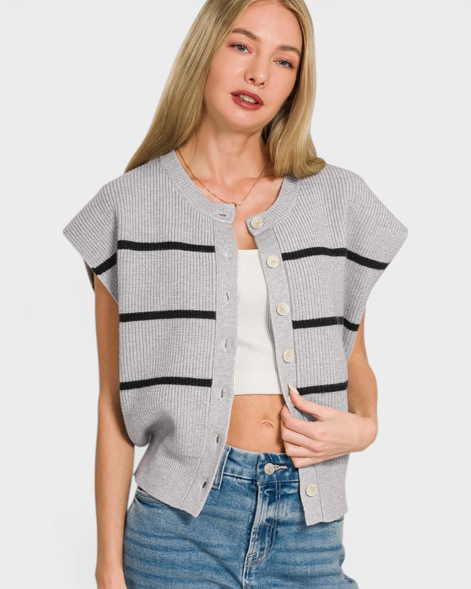 Woman wearing a gray cardigan with black stripes on a white background