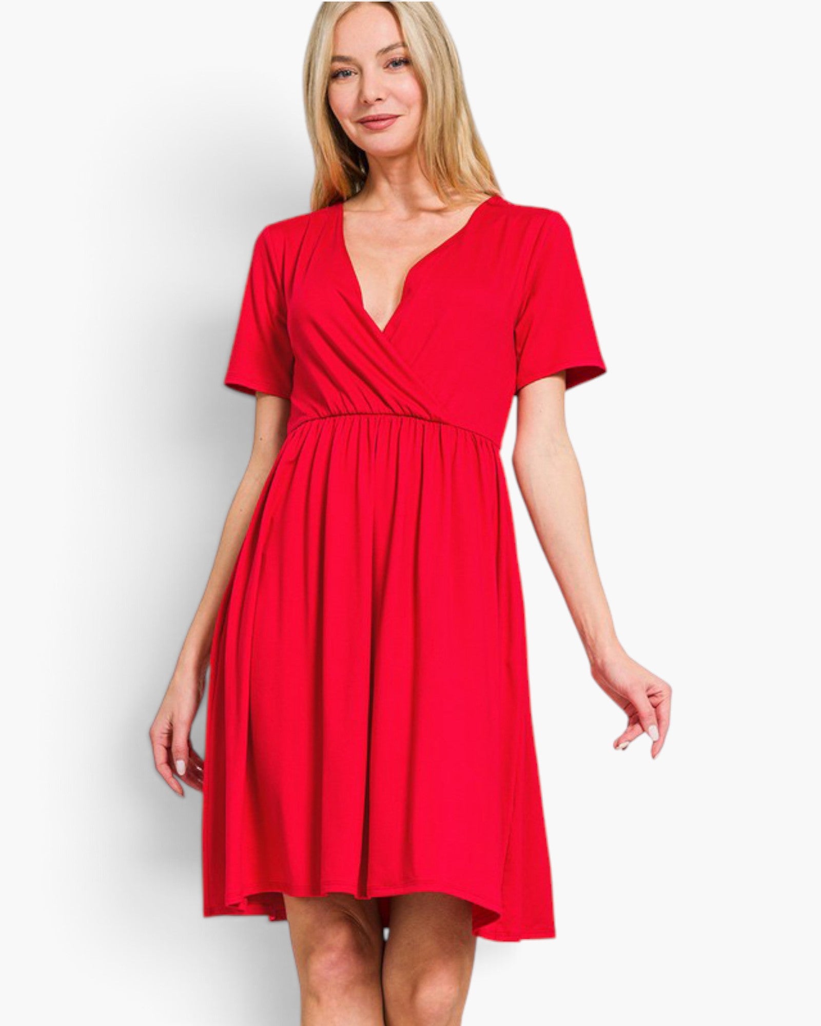A woman modeling a bright red short-sleeve wrap-style dress with a V-neckline and gathered waist, photographed against a plain light gray studio background.