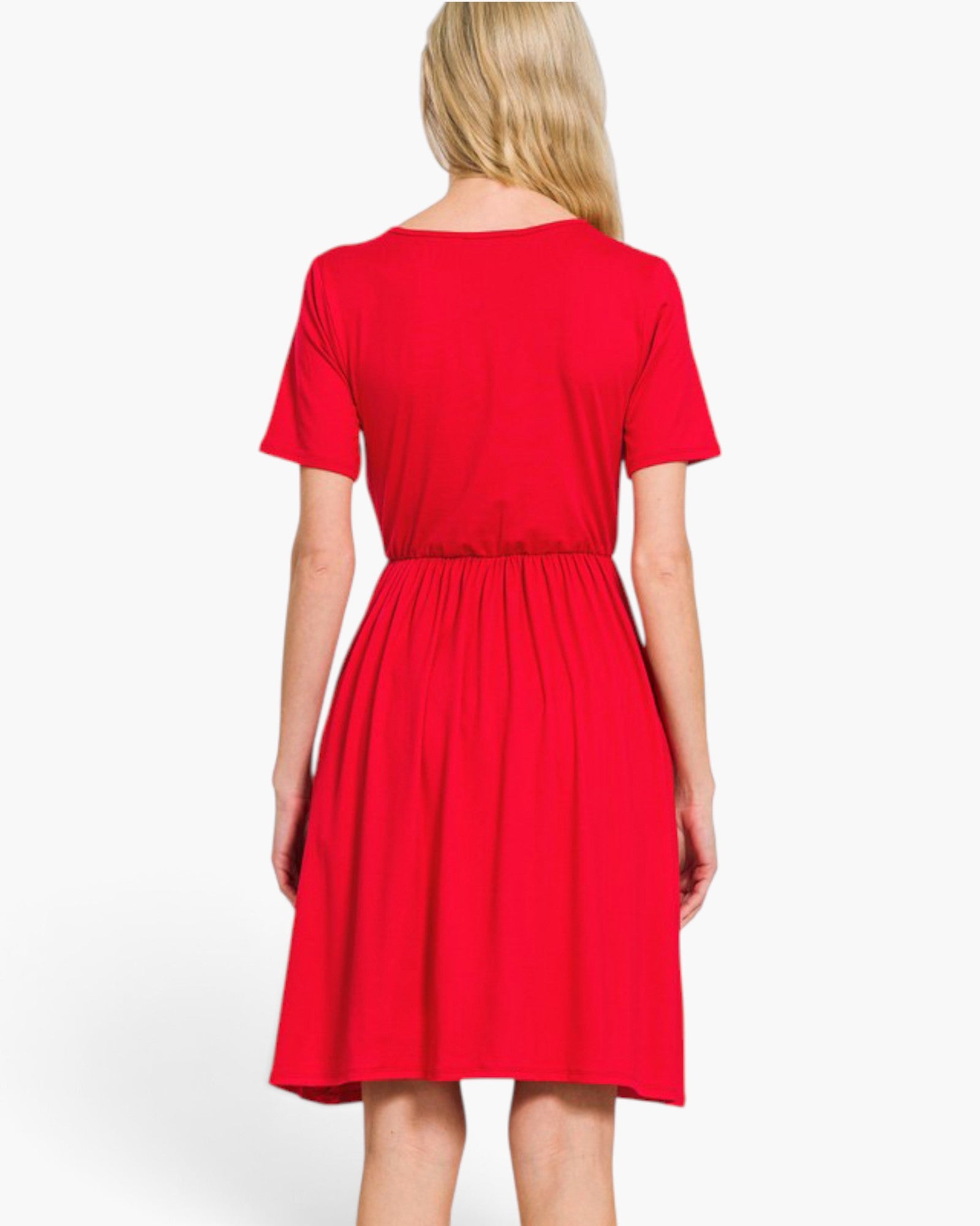A woman modeling a bright red short-sleeve wrap-style dress with a V-neckline and gathered waist, photographed against a plain light gray studio background.