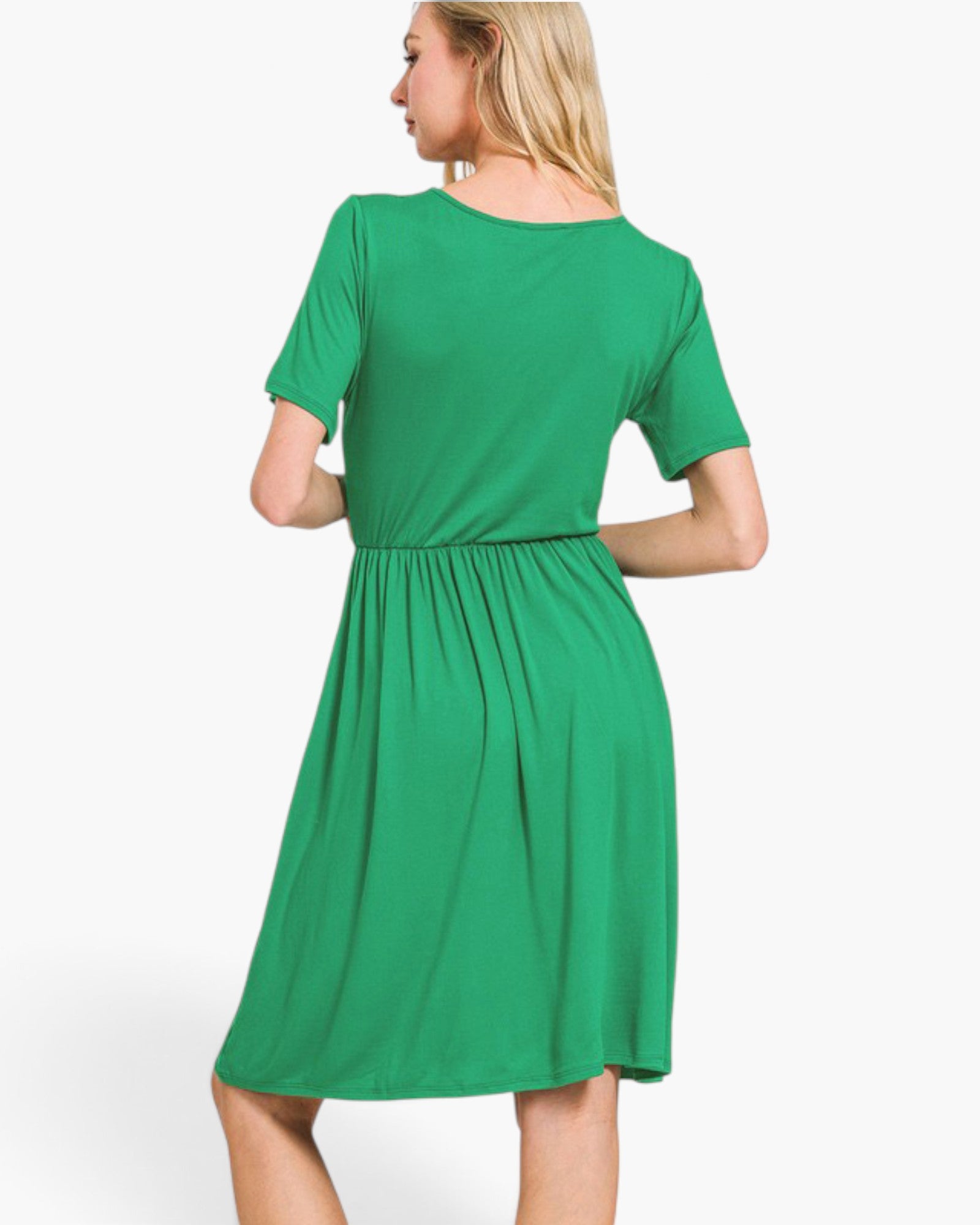 A woman wearing a bright green short-sleeve dress, shown from the back against a plain light gray studio background.