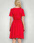 Red dress worn by a person on a plain background