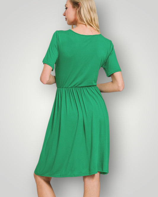 Green dress worn by a person on a plain background