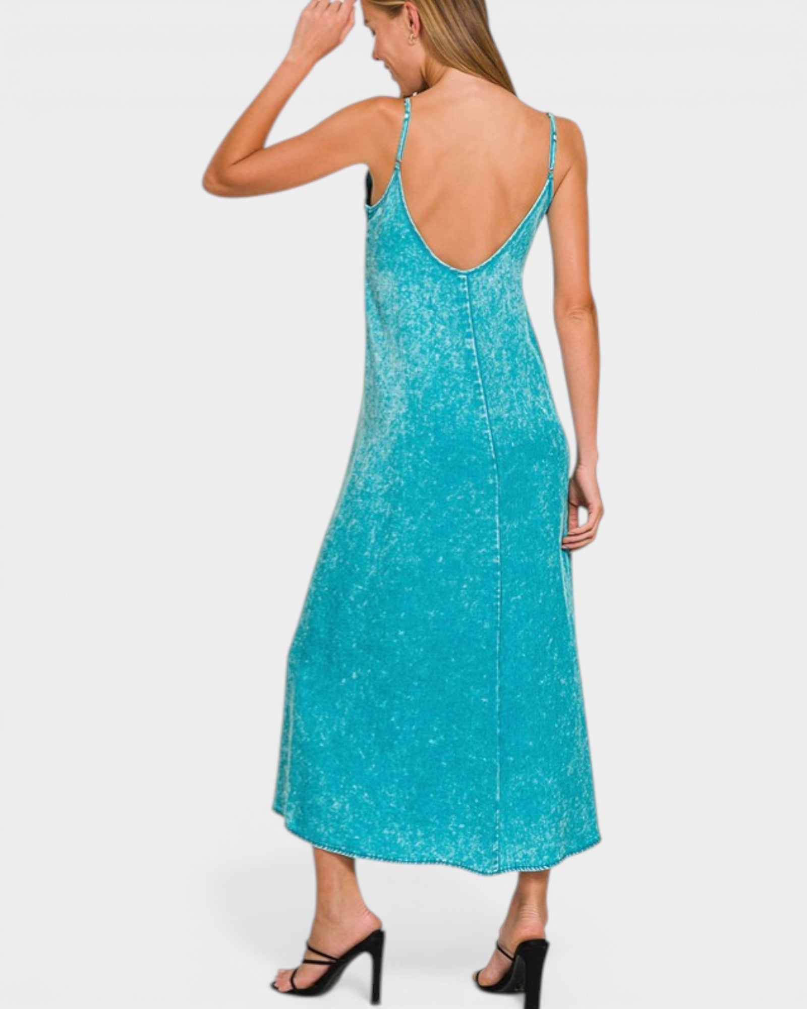 Woman wearing a turquoise slip dress on a white background