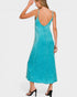Woman wearing a turquoise slip dress on a white background