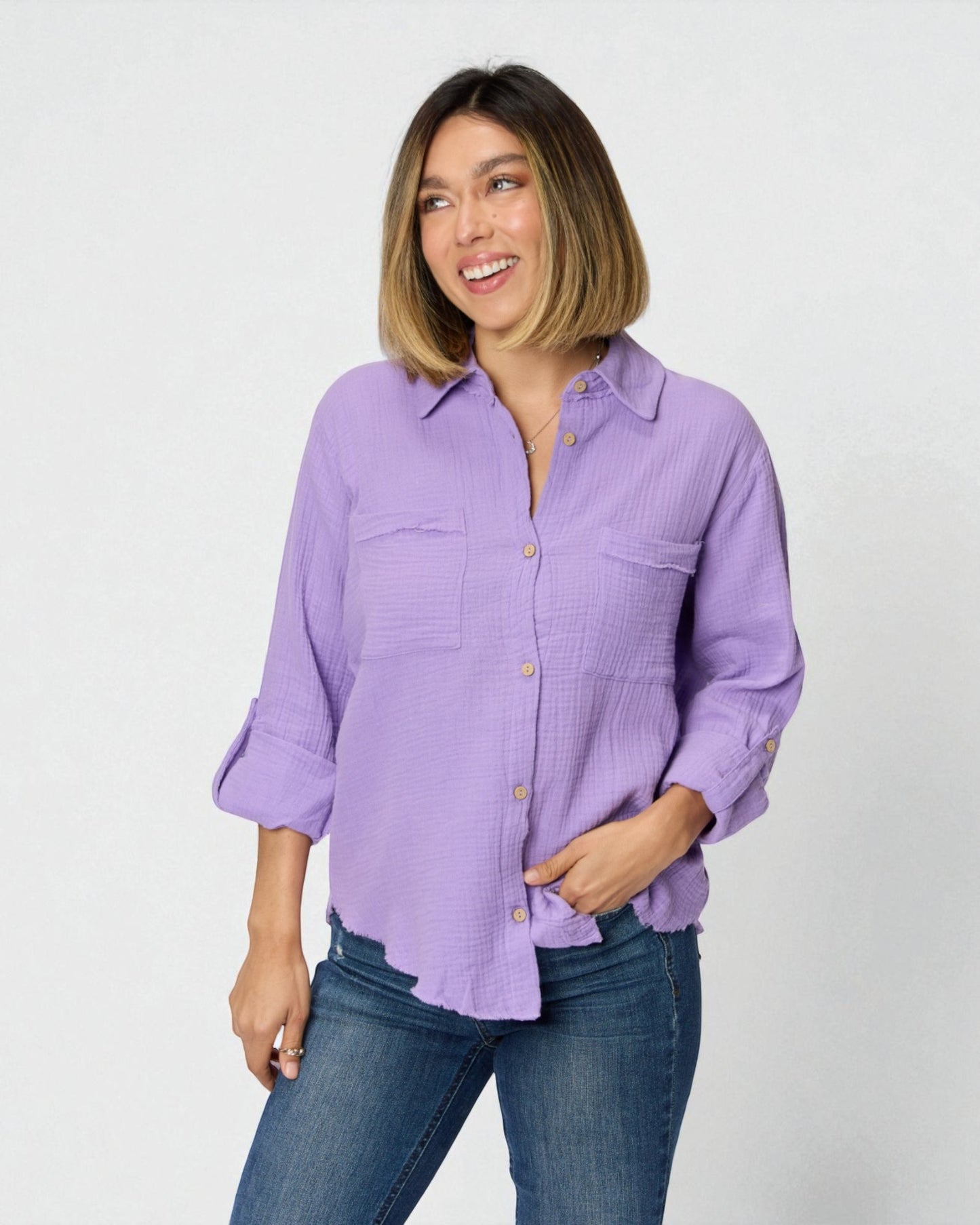 Woman wearing a purple shirt and blue jeans on a white background