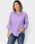 Woman wearing a purple shirt and blue jeans on a white background