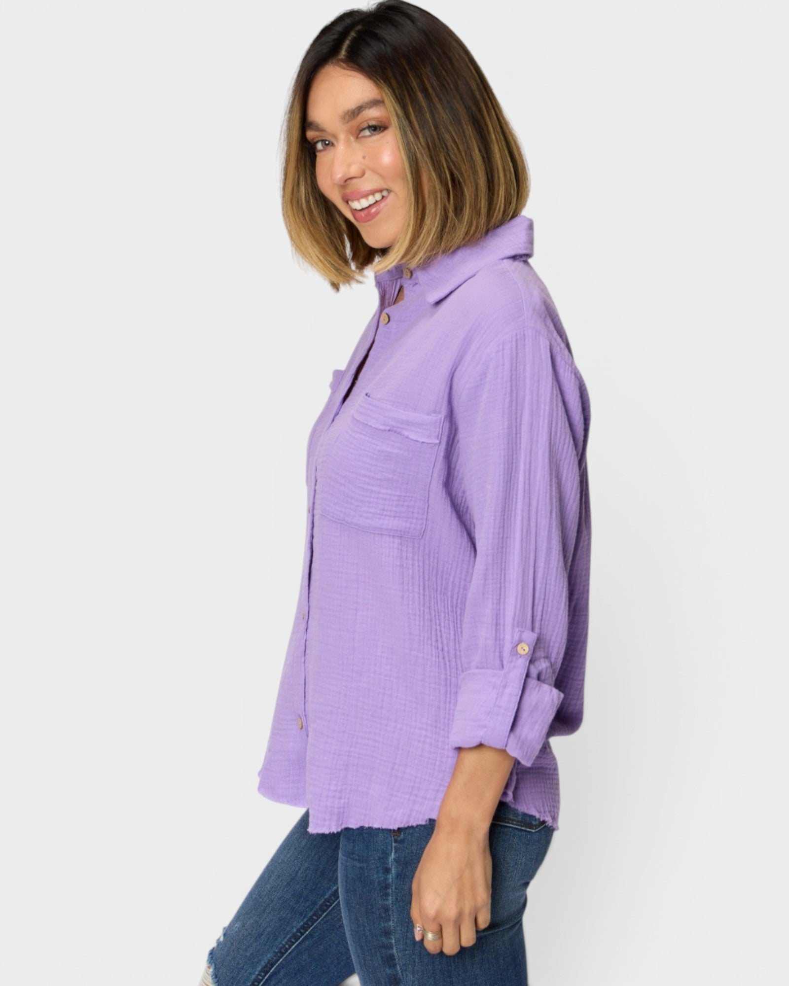 Woman wearing a purple shirt and jeans on a white background