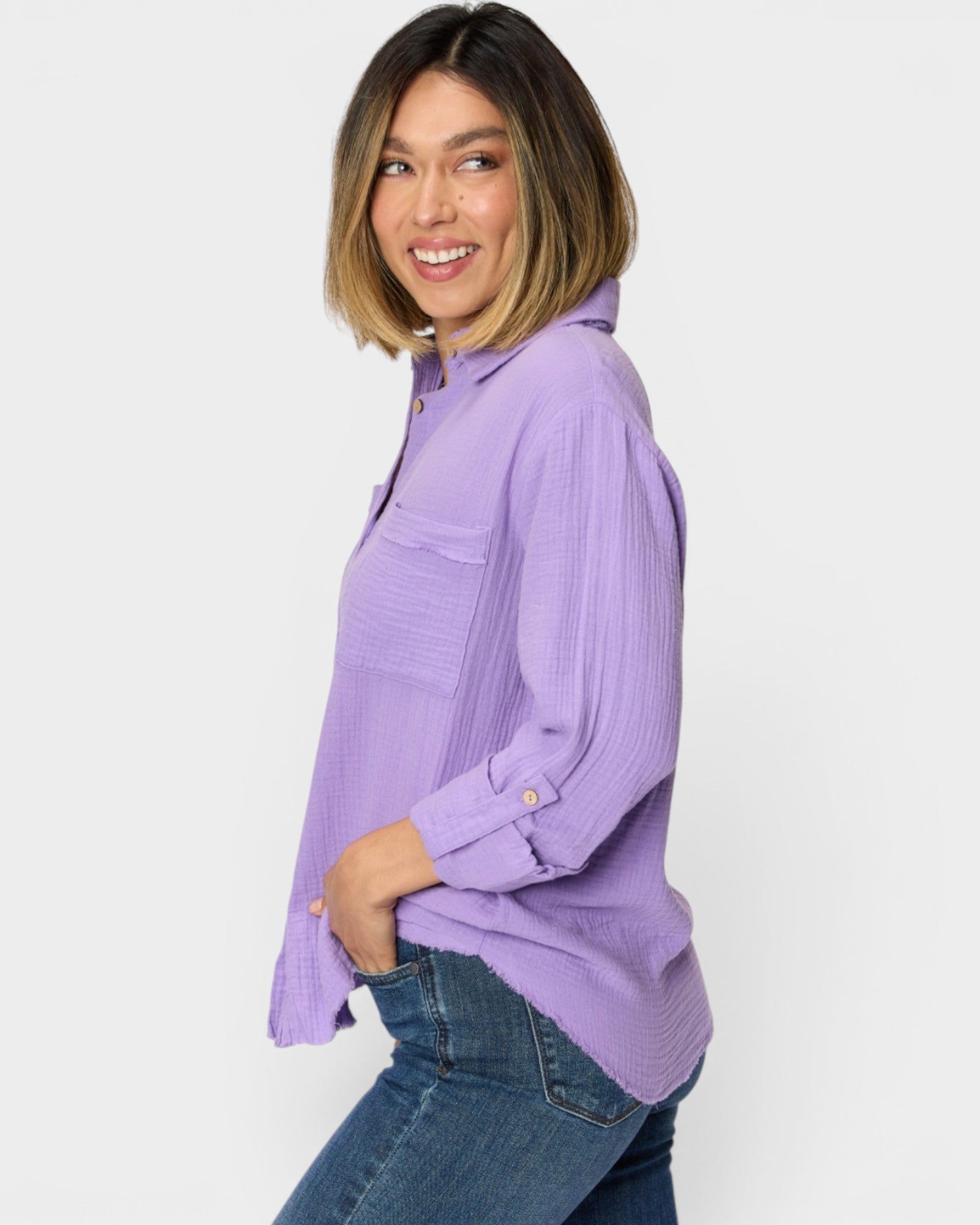 Woman wearing a purple shirt and blue jeans on a white background