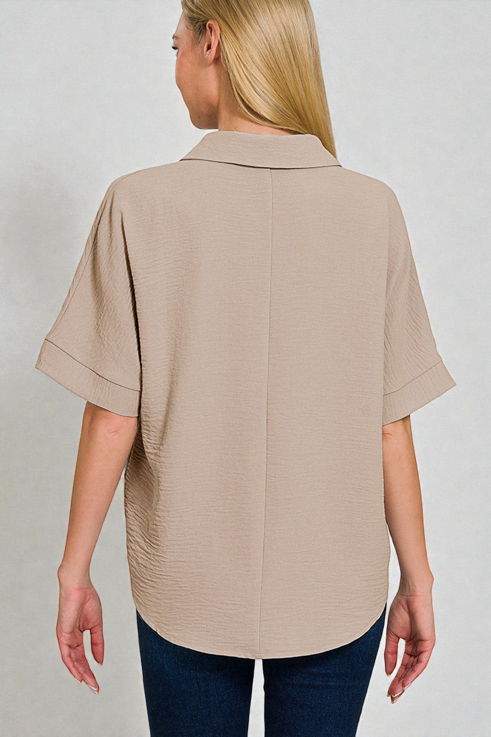 Beige short-sleeve shirt worn by a person on a plain background