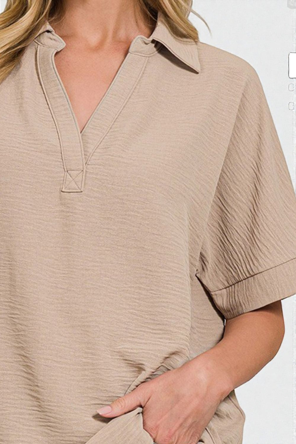 Beige short-sleeve shirt worn by a person on a white background
