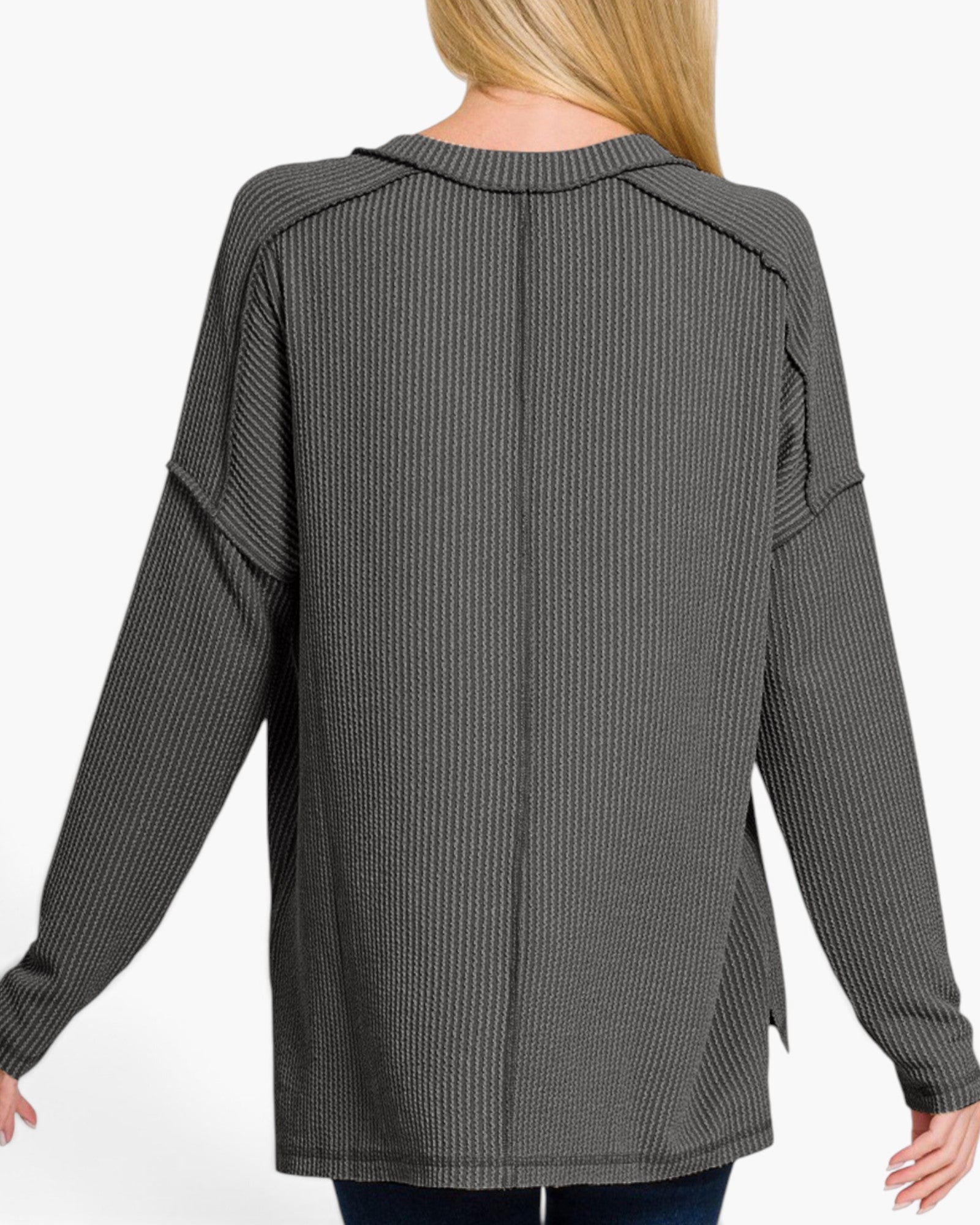 A woman wearing a dark gray ribbed knit long-sleeve top, shown from the back against a plain white background.