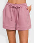Pink quilted shorts with a drawstring on a white background