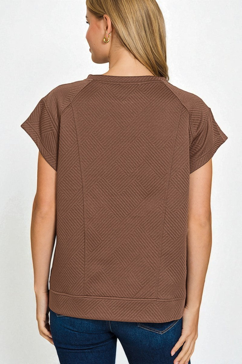 Brown textured top worn by a person on a white background