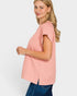 Woman wearing a pink short sleeve top on a white background