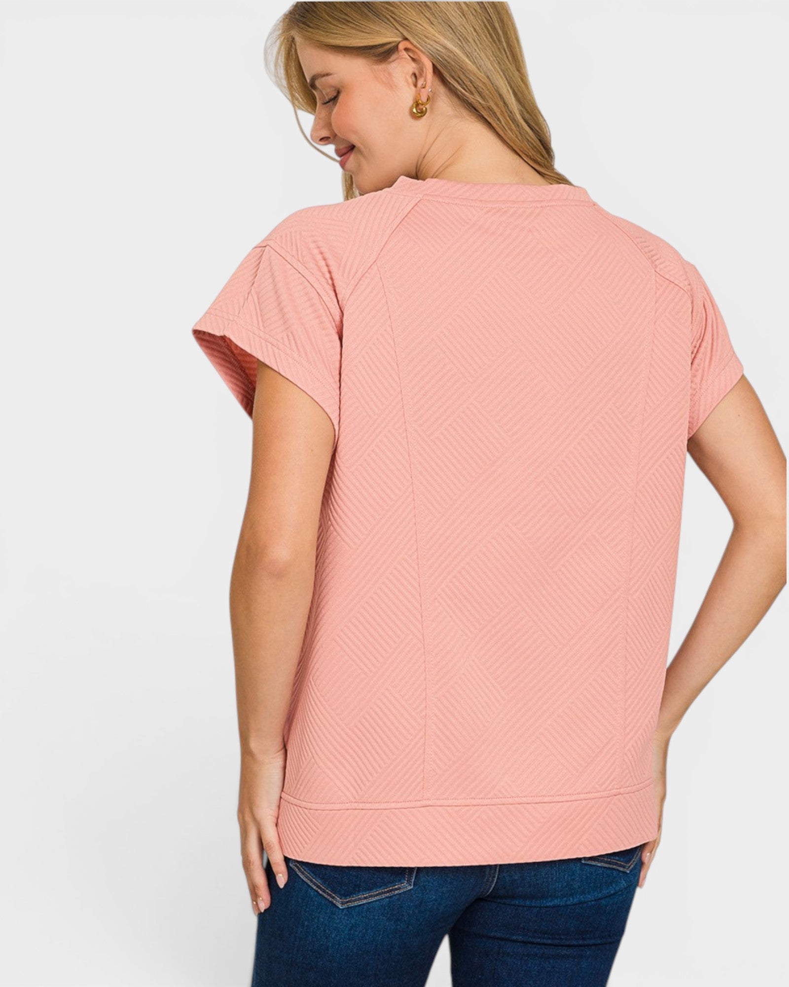 Woman wearing a pink short-sleeve top on a white background