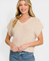 Woman wearing a beige knitted top and blue jeans on a white background