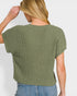 Woman wearing a green knitted top against a plain background