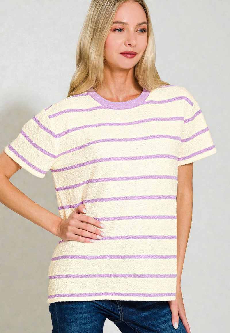 Woman wearing a yellow and purple striped shirt against a plain background
